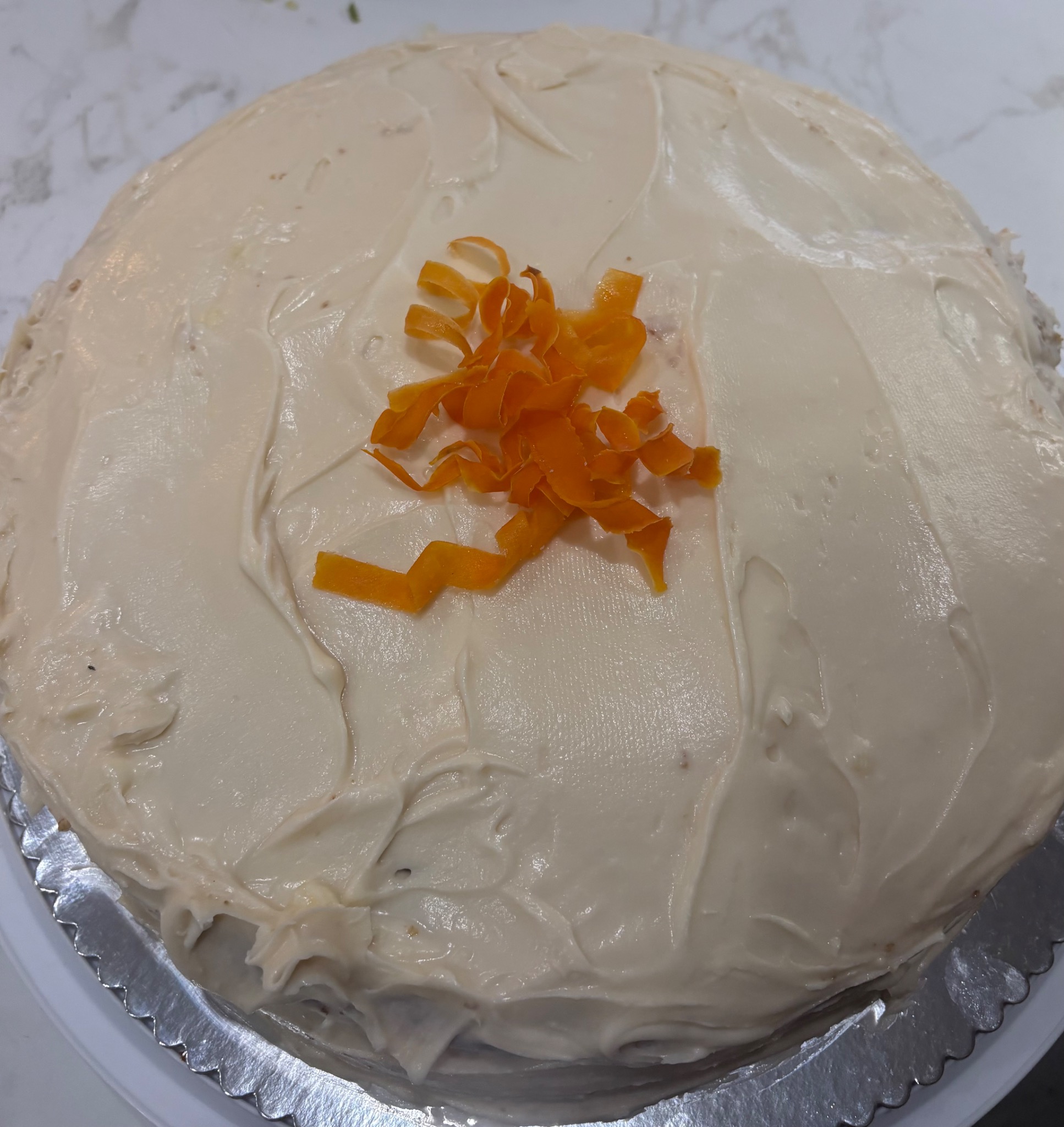 Frosted cake topped with orange curls