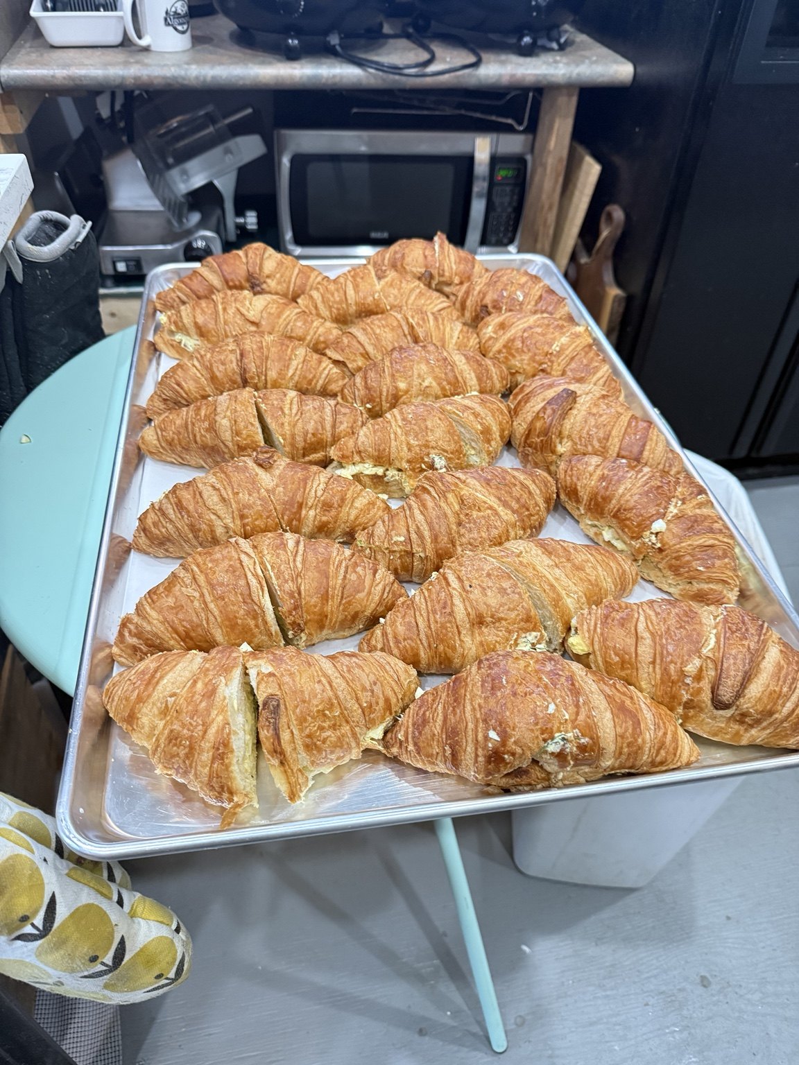 A tray of filled croissant sandwiches prepared for catering