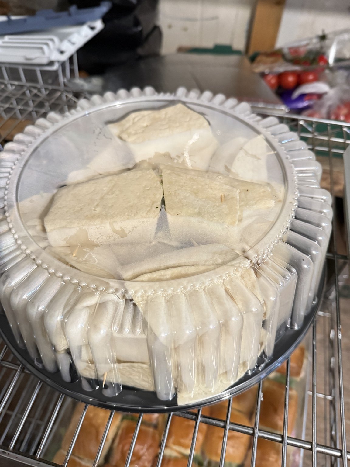 A covered platter of wraps prepared for catering