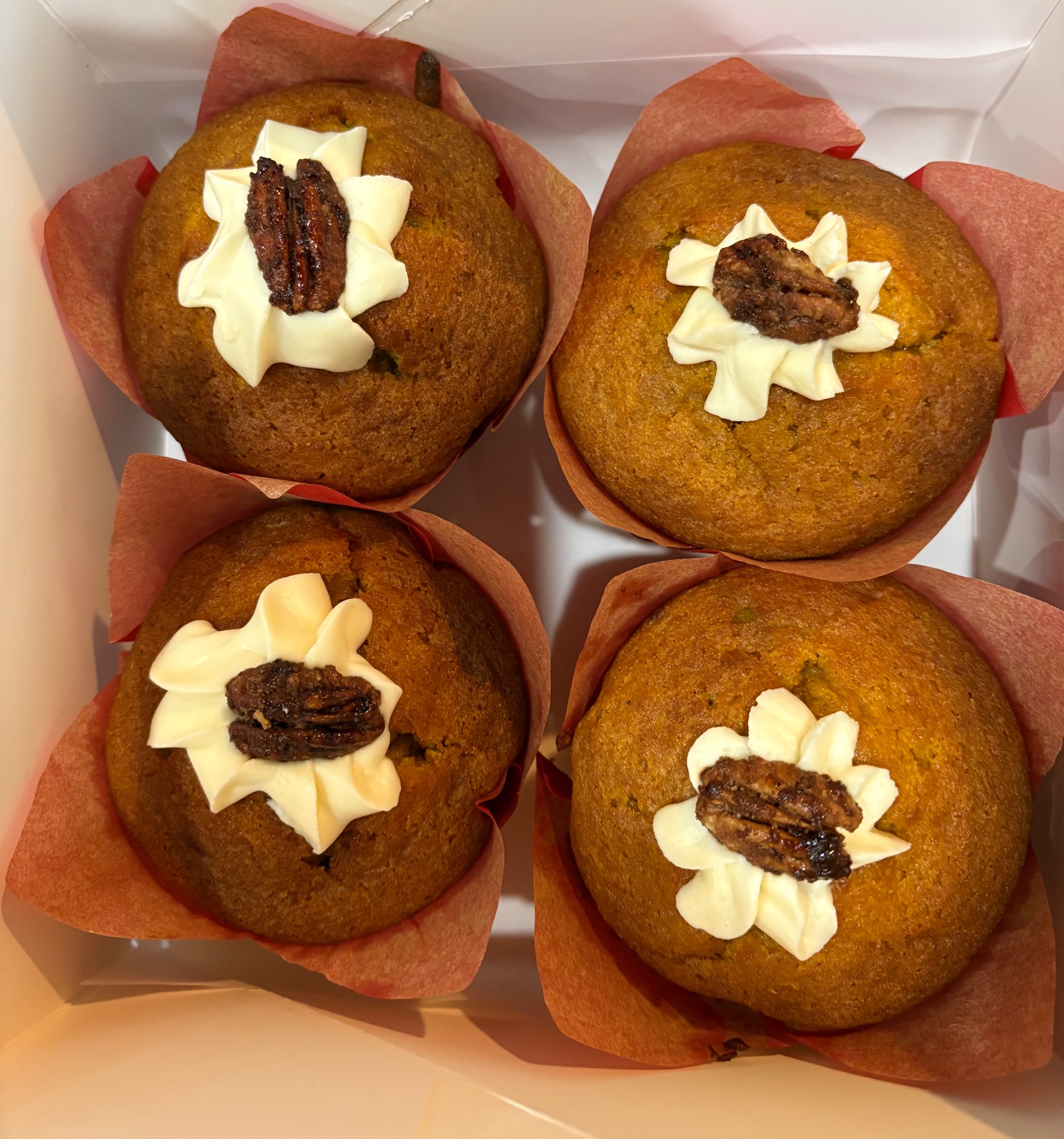 Muffins topped with icing and pecans