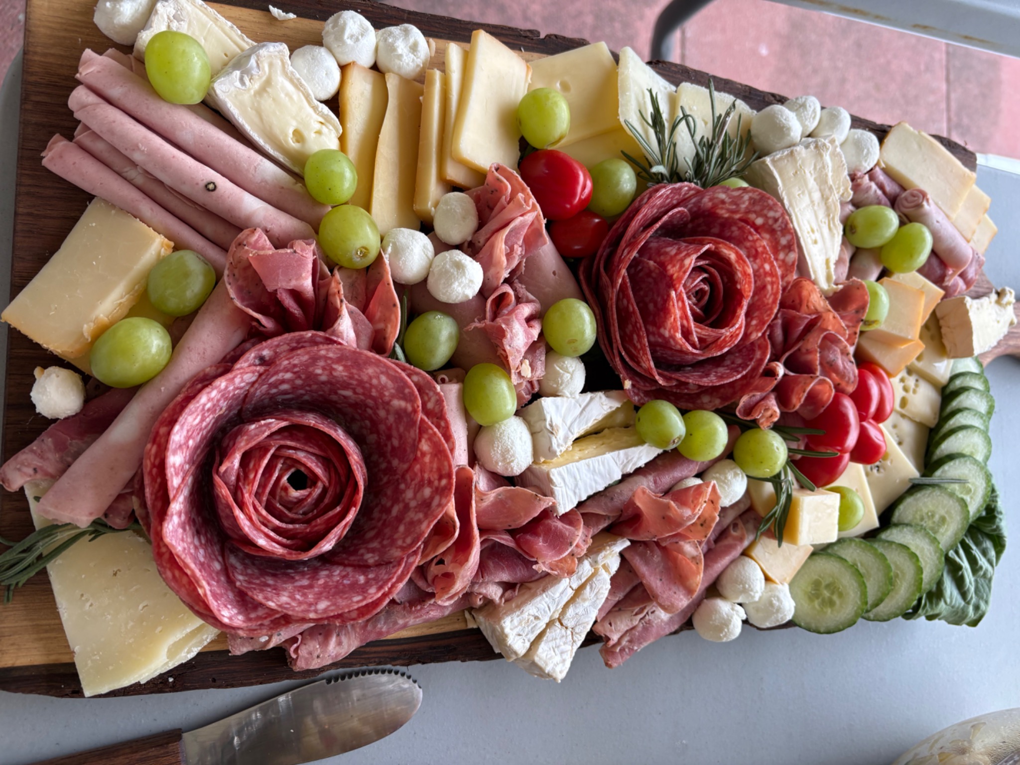 Charcuterie board with meats, cheeses and grapes